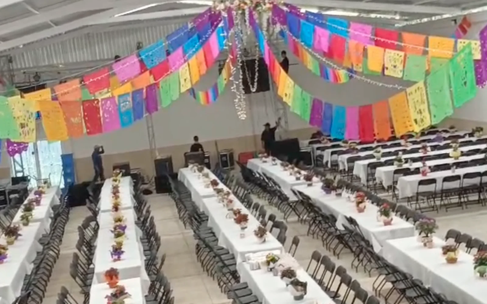 Salón principal de Santa Elena montado con mesas para banquete, papel picado y luces en el techo
