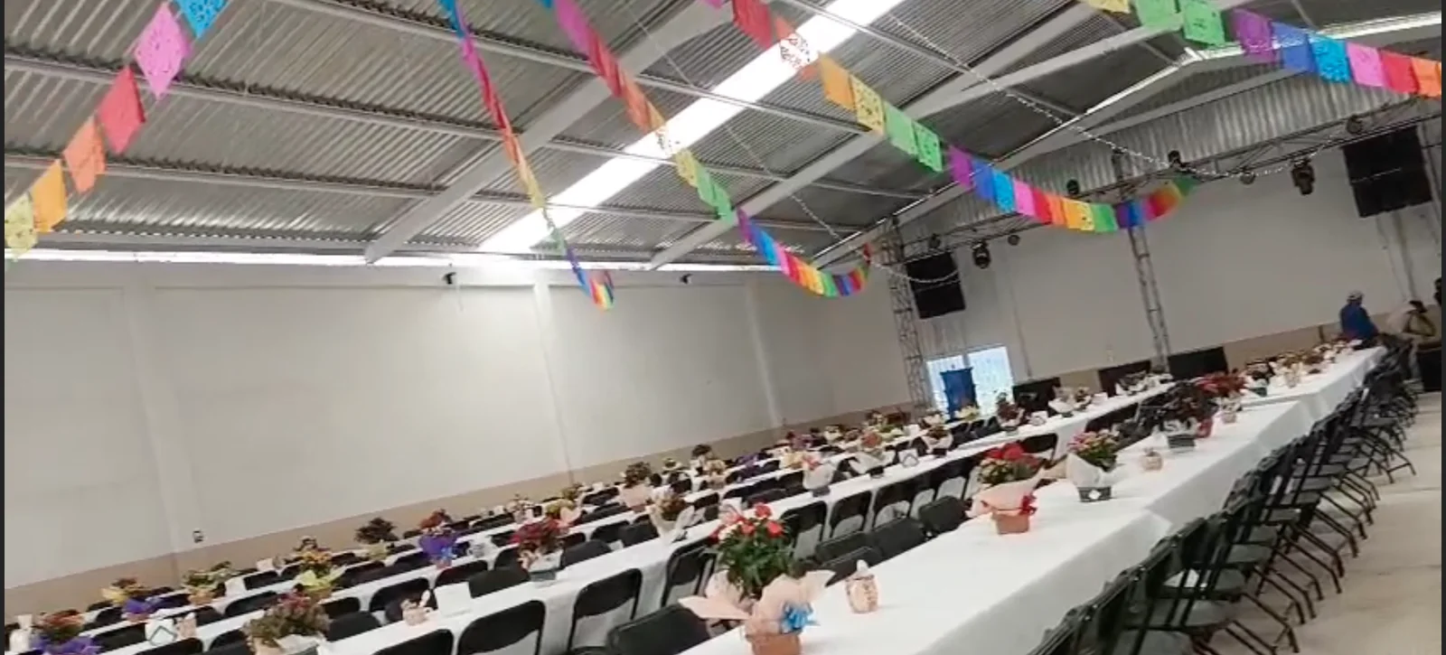 Mesas de banquete montadas bajo el papel picado